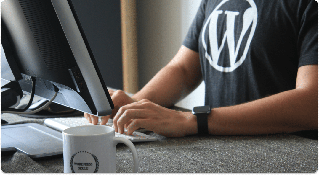 Person sits at a computer wearing a WordPress logo shirt.